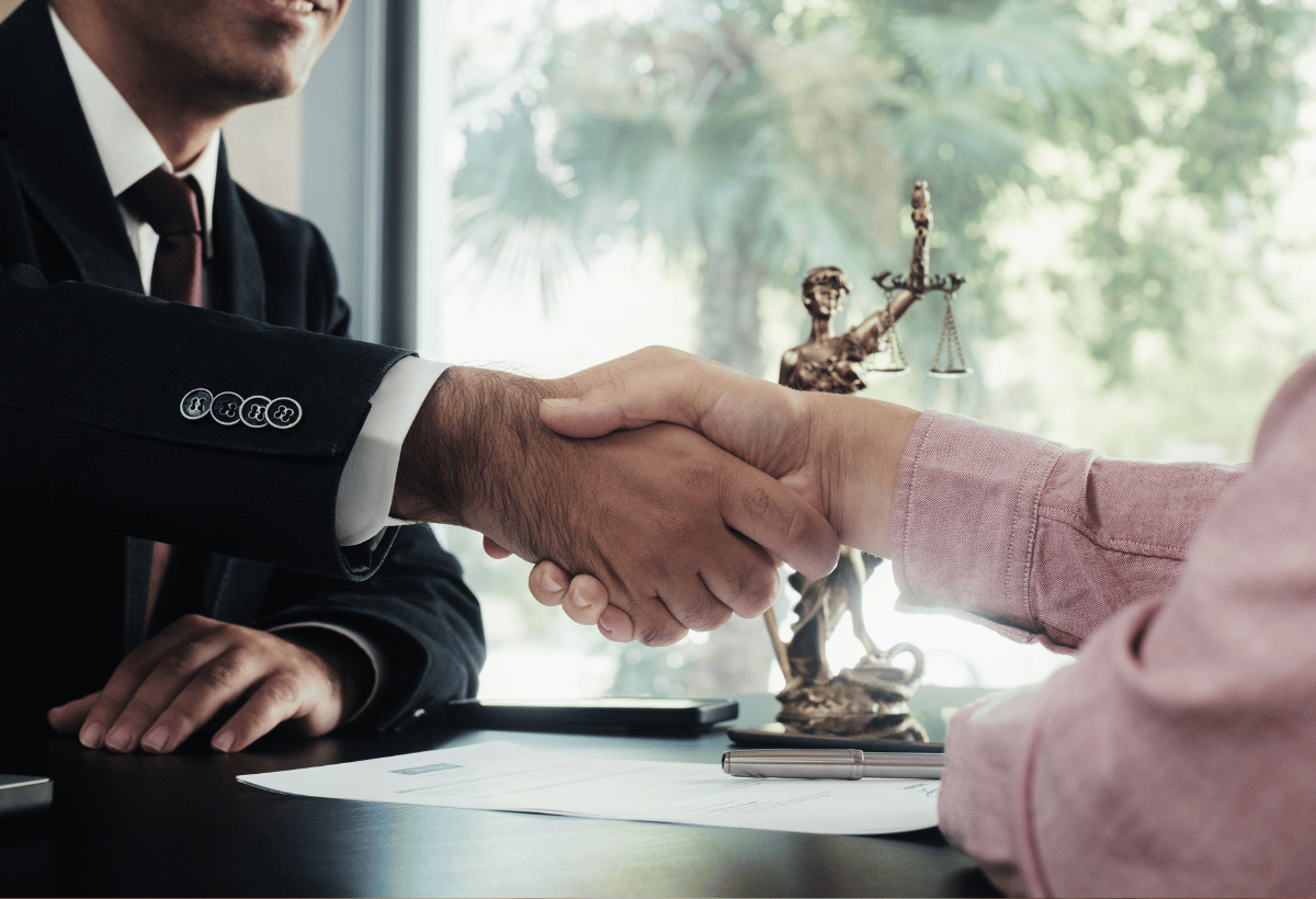 Advogado cumprimentando cliente em reunião sobre responsabilidade jurídica e prevenção de riscos legais.