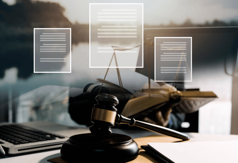 Martelo de juiz, balança da justiça e documentos jurídicos sobre mesa, representando orientação jurídica preventiva na gestão de empresas e condomínios.