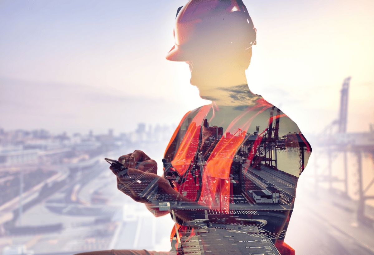 Trabalhador com EPI usando celular em área industrial, simbolizando riscos operacionais e segurança do trabalho